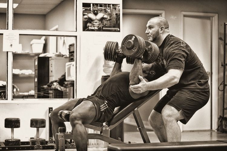 Craig Bongelli spotting a client on a dumbbell press